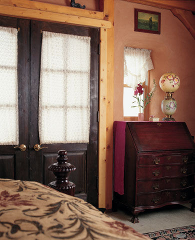 
Salvaged interior doors complement vintage tag-sale purchases and family antiques in Chris and Paula’s bedroom.
